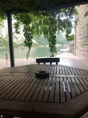 a picnic table with a bench and a view of the water at Seaside dream in Trstenik