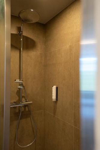 a shower with a shower head in a bathroom at Green Hotel in Genk