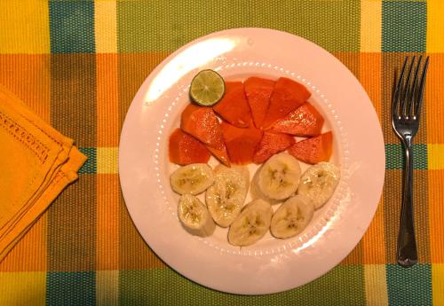 a plate of fruit on a table with a fork at Mannankulam Villa in Akkaraipattu