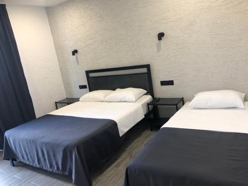 two beds in a hotel room with two bedsskirts at Hotel West Way in Kutaisi