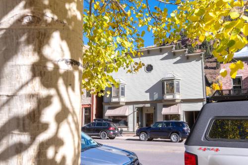 a street with cars parked in front of a house at Telluride Mainstreet 2 Bedroom Condo in Telluride