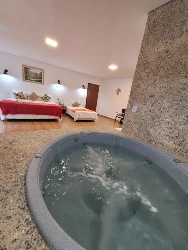 a bath tub in a room with a bedroom at Pousada Sr. Ivan in Serra do Cipo