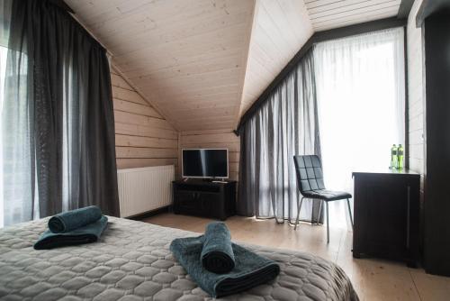 a bedroom with a bed with two towels on it at Chalet Carpat Dream in Synevyr