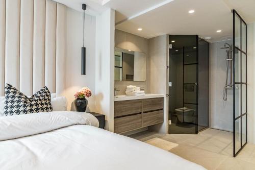 マルベーリャにあるLAB-Modern Penthouse San Pedro Centerのベッドルーム(大型ベッド1台付)、バスルームが備わります。