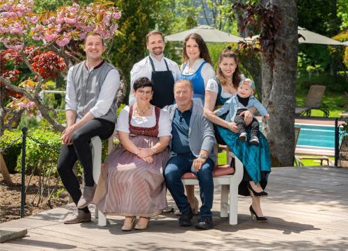 a family posing for a picture on a bench at Parkhotel Flora am Schluchsee in Schluchsee