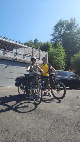 zwei Männer stehen mit ihren Fahrrädern auf einem Parkplatz in der Unterkunft La Maison De Marie in Binche