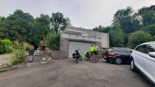 zwei Personen mit Fahrrädern auf einem Parkplatz mit Garage in der Unterkunft La Maison De Marie in Binche