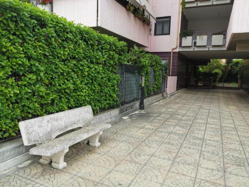 a bench sitting on a sidewalk next to a building at NSM La Vie en Rose in Foggia