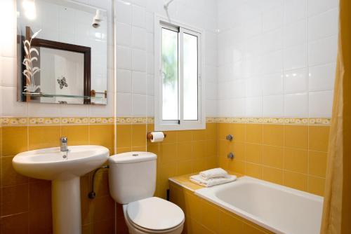 a bathroom with a toilet and a sink and a tub at Casa Paqui 1 in Roche