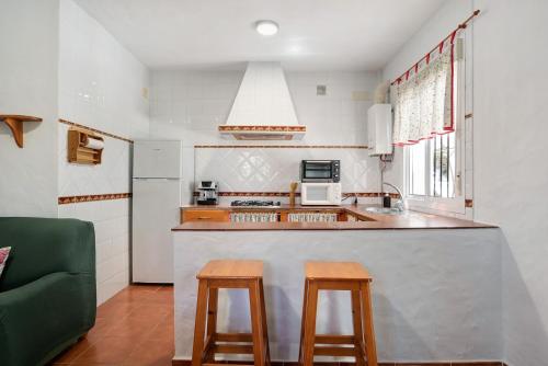 a kitchen with a counter and two wooden stools at Casa Paqui 1 in Roche
