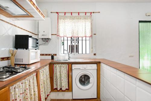 a kitchen with a washing machine and a window at Casa Paqui 1 in Roche