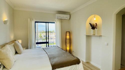 a bedroom with a bed and a large window at Jardim da Oura by Check-in Portugal in Albufeira