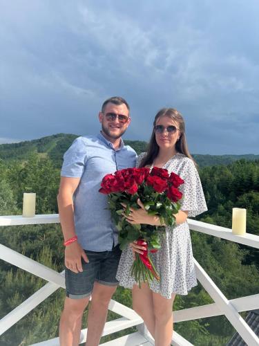 a man and woman holding a bouquet of red roses at Karpaty Migovo in Migovo
