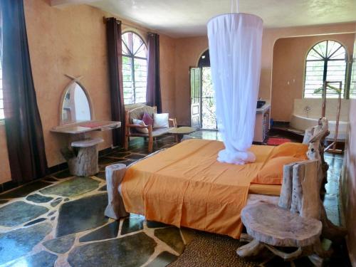 1 dormitorio con 1 cama grande con dosel blanco en Wagawimbi Villa 560 m2, Breathtaking View of the Indian Ocean, Kenya, en Shimoni