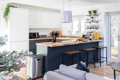 a kitchen with a blue island in a living room at Gorgeous SeaHaze sleeps 8 new forest +bikes/chef in Everton