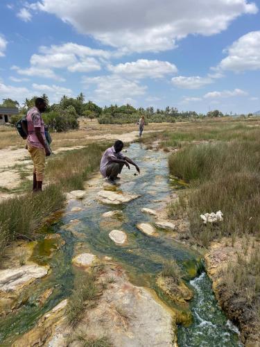 two people are standing in a stream of water at Wagawimbi Villa 560 m2, Breathtaking View of the Indian Ocean, Kenya in Shimoni