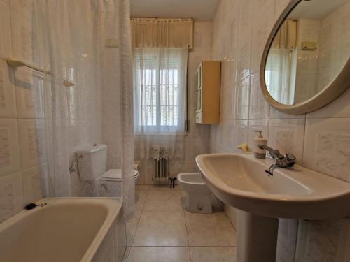 y baño con bañera, lavabo y espejo. en Precioso apartamento con piscina - Covelo en Pontevedra