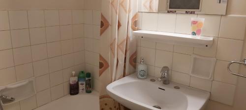 a white bathroom with a sink and a toilet at The comfy flat in Athens