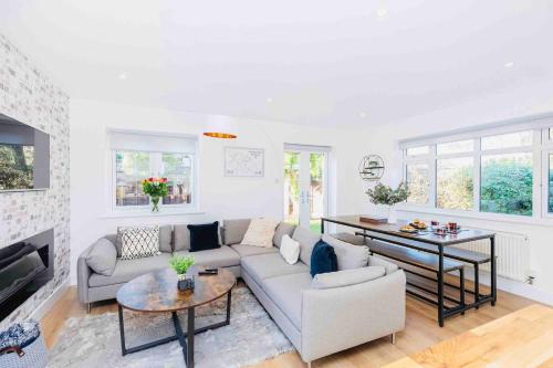 a living room with a couch and a table at Gorgeous SeaHaze sleeps 8 new forest +bikes/chef in Everton