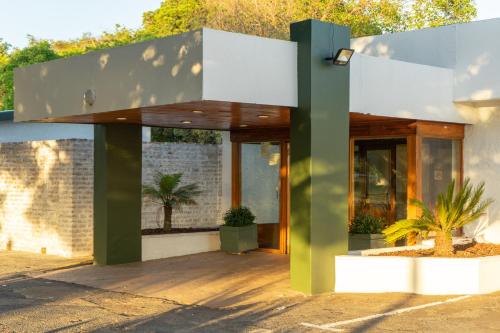 a house with a green and white facade at Brinkley's River Village in Klein Brak Rivier