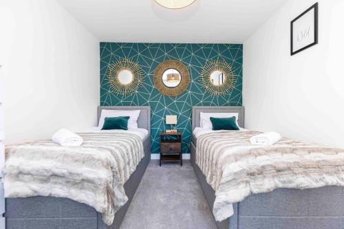 a bedroom with two beds and two mirrors on the wall at Gorgeous SeaHaze sleeps 8 new forest +bikes/chef in Everton