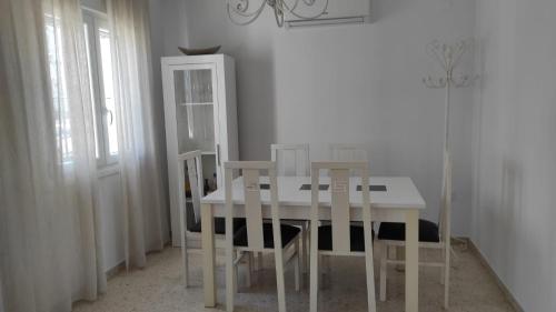a dining room with a white table and chairs at Casa Rubio in Chiclana de la Frontera