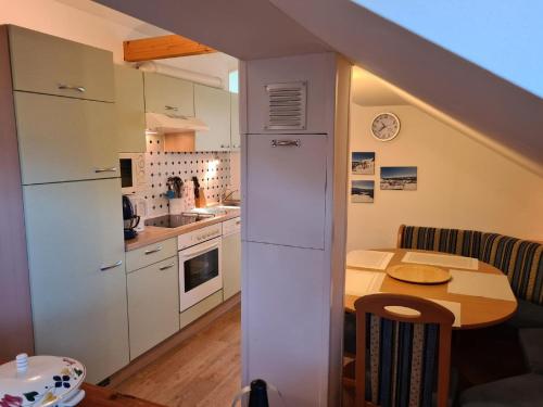 バート・ミッテルンドルフにあるApartment in Bad Mitterndorf with sauna ski storage and gardenの白いキャビネットとテーブル付きのキッチンが備わります。