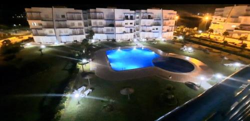 a swimming pool in front of a building at night at Lovely Apartment in CABO, RIVIERA BEACH in Cabo Negro