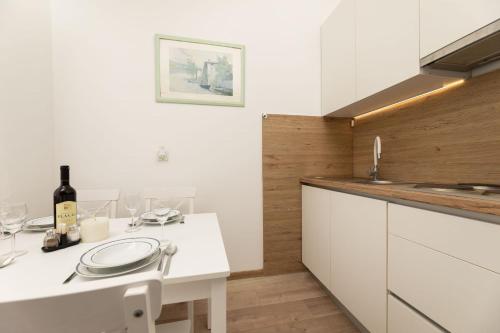 a kitchen with white cabinets and a white counter top at Apartments Danica by EL-PI TOURS in Njivice