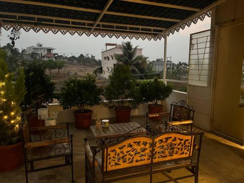 a balcony with chairs and a table with a view of a city at Myra's house in Kolhapur