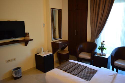 a hotel room with a bed and a flat screen tv at Ream Hotel Amman in Amman