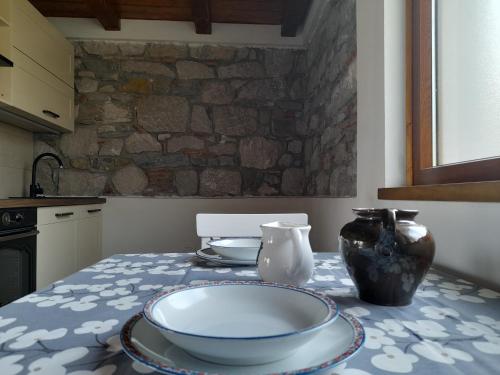 una mesa de cocina con un tazón y jarrones. en Pri Piskovih, en Grgar