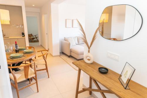 a living room with a dining room table and a mirror at Casa Los Lances Deluxe - Reformado Junto a la Playa y Terraza in Tarifa