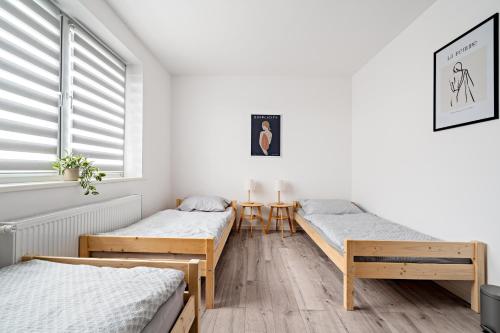 1 dormitorio con 3 camas y ventana en Noclegi Krańcowa, en Zgorzelec