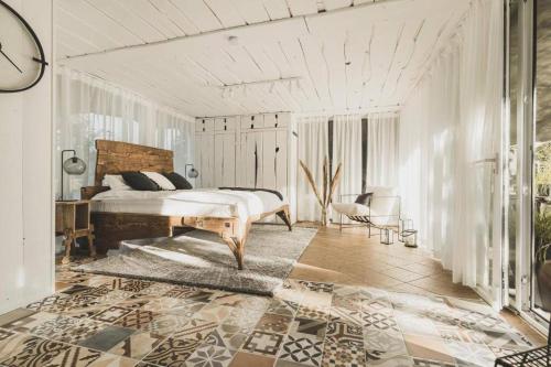 Your Private Retreat Island في Priedkalne: غرفة نوم بيضاء بها سرير وغرفة بها
