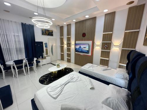 Pokój szpitalny z dwoma łóżkami i stołem w obiekcie ESTO's Apartament near Tirana Airport 1 - Self CheckIN -Netflix - FREE Parking w mieście Valjiosi