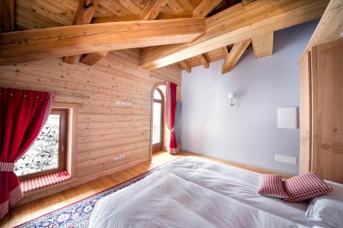 Albergo Monte Cervino في تشامبولوك: غرفة نوم بسرير كبير في غرفة خشبية