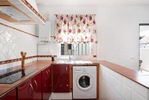 a kitchen with a washing machine and a window at Casa Paqui 3 in Roche