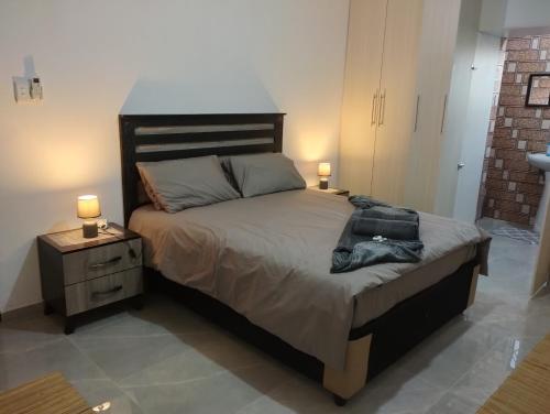 a bedroom with a large bed with two lamps on it at Wanderlust Hostel in Bergville