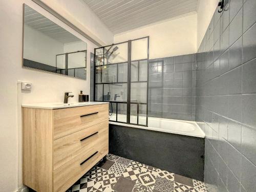 a bathroom with a sink and a bath tub at Au Cœur Ardéchois - Avec terrasse ombragée in Joyeuse