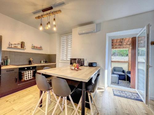 une cuisine avec une grande table et des chaises en bois dans l'établissement Au Cœur Ardéchois - Avec terrasse ombragée, à Joyeuse