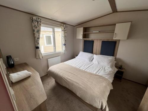 a bedroom with a large bed and a window at Lolas Lodge in Lossiemouth