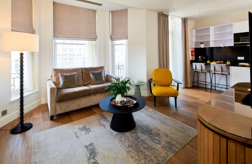a living room with a couch and a table at Cheval Harrington Court at South Kensington in London