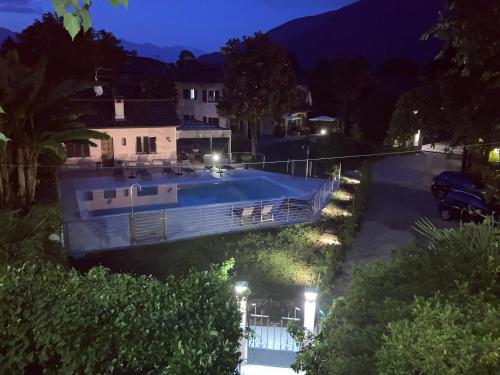 a boat in the water at night at Residence Villa Margherita WITH POOL & HYDROMASSAGE in Cannobio