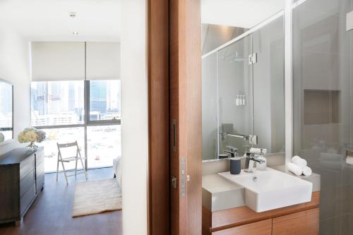 een badkamer met een witte wastafel en een spiegel bij Nasma Luxury Stays - City Walk Building 5 in Dubai