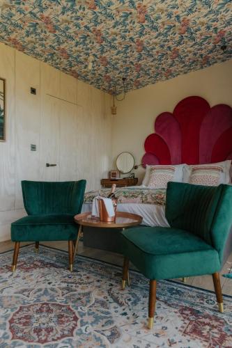 a bedroom with a bed and two chairs and a table at Newton Hall in Chathill