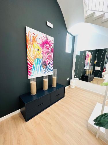 a living room with a painting of a zebra at Apartamentos Hotel Puente de Hierro in Benicàssim
