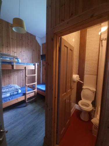 a bathroom with a toilet and two bunk beds at Blackwater Hostel in Kinlochleven