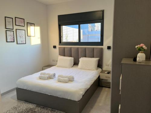 a bedroom with a bed with two towels on it at Aramis Suite in Neot Golan