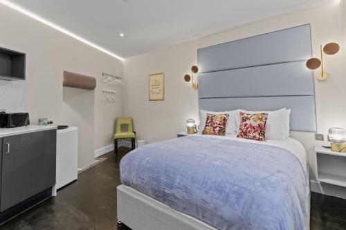 a bedroom with a large bed and a kitchen at Modern Studio Flat in London